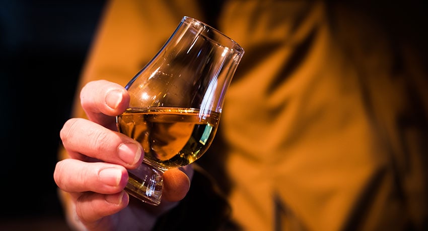 Person holding a glass of rum