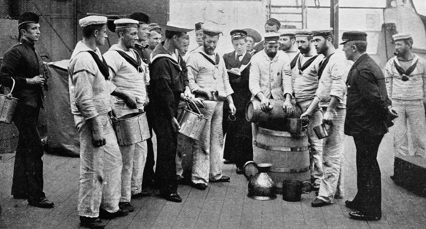 People standing around a rum barrel