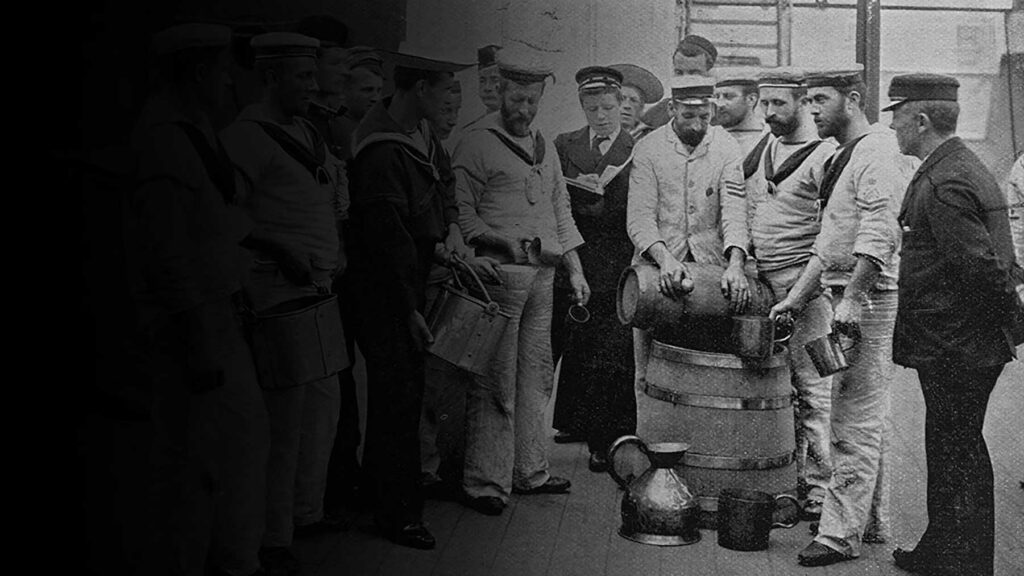 People standing around a rum barrel