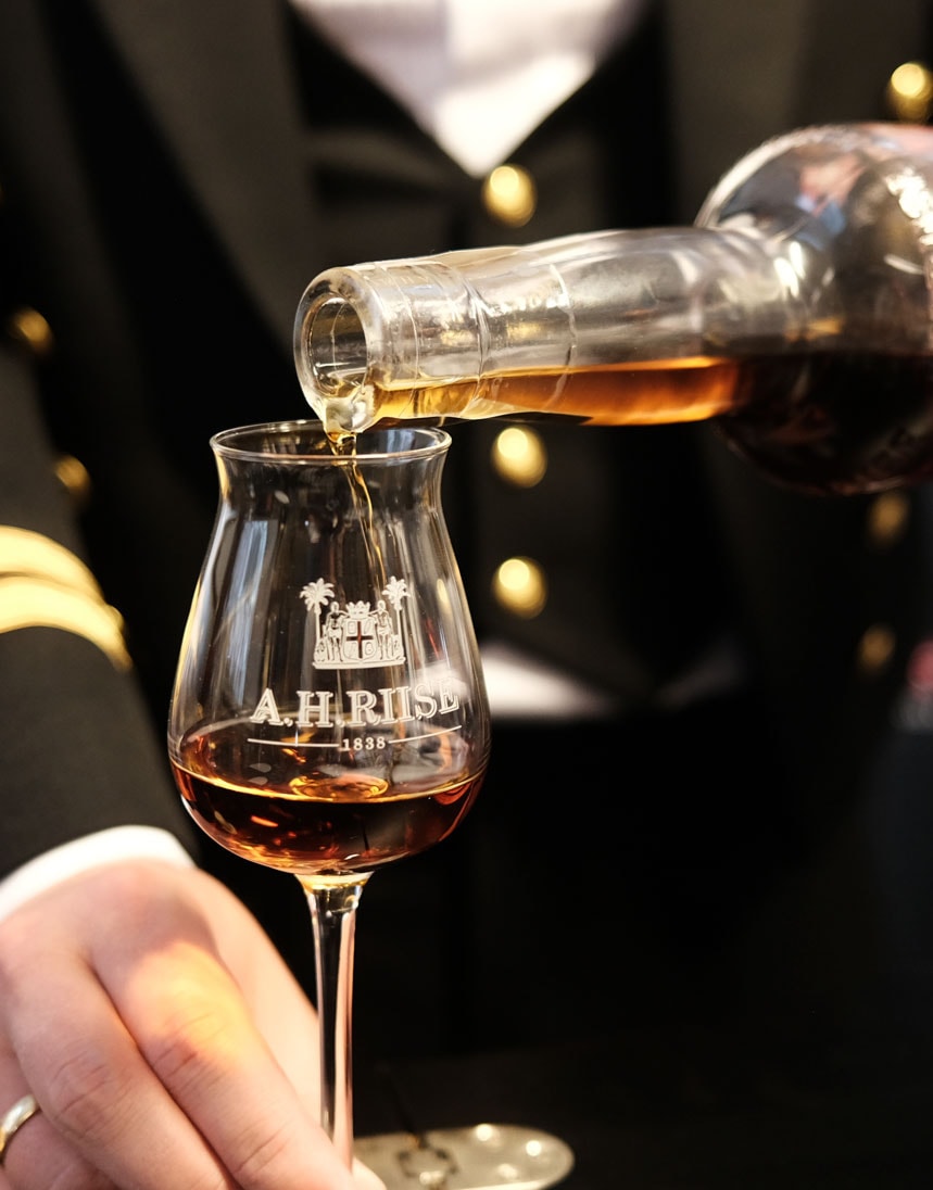 A person pouring a glass of rum - Royal Danish Navy